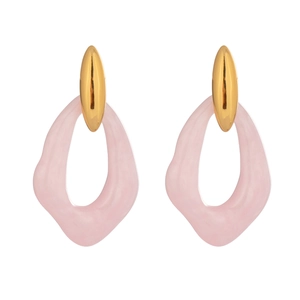 Close-up of irregular pink resin earrings with gold oval metal studs on white backdrop