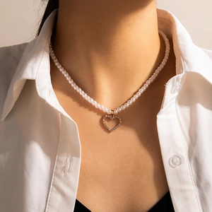 Close-up of pearl necklace featuring a sparkling crystal-encrusted hollow heart pendant