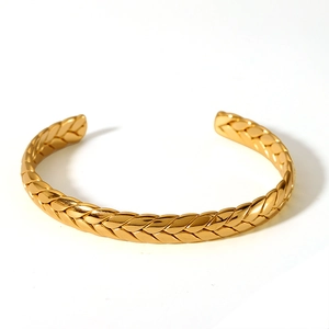 Detailed view of 18K gold plated stainless steel knotted bangle with woven texture