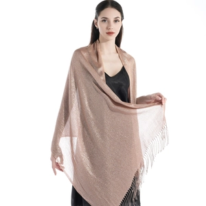 Close-up of champagne gold glitter shawl featuring fringe tassels and shimmering fabric