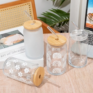 Detail of four glass tumblers with bamboo lids featuring frosted and printed patterns
