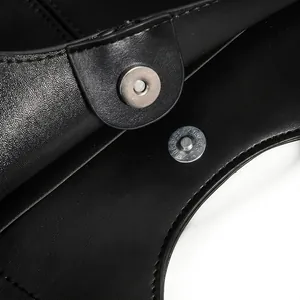 Macro detail of high-quality black leather tote bag with a circular magnetic snap closure