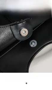 Macro detail of high-quality black leather tote bag with a circular magnetic snap closure