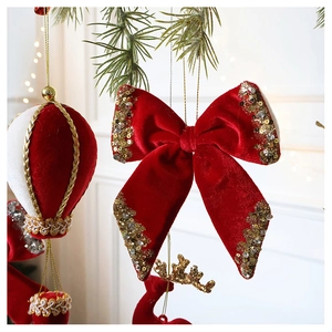 Detail of red velvet Christmas bow with gold sequins and a hot air balloon ornament