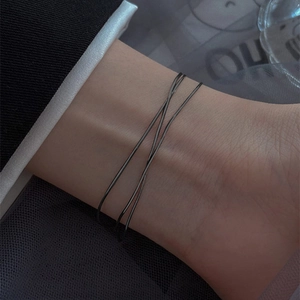 Detail of a minimalist double-layered black blade chain bracelet in 18k gold-plated steel