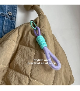 Close-up of khaki quilted tote bag with a contrast color woven rope charm detail