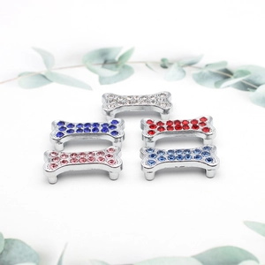Macro shot of 8mm bone-shaped charms with colorful rhinestones on a clean white backdrop