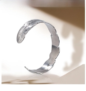 Close-up of retro silver feather texture on adjustable stainless steel bangle