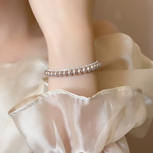 Elegant double-layered rose pearl and zircon tennis bracelet on a white fabric sleeve