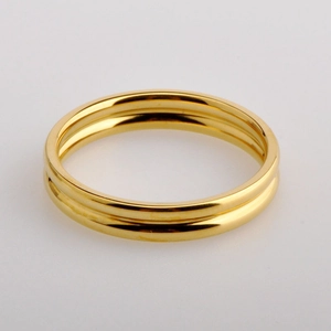 Macro shot of minimalist 18k gold double band ring with polished metallic finish