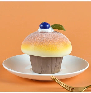Detail shot of a PU foam mushroom cupcake fridge magnet with blue berry on a white plate