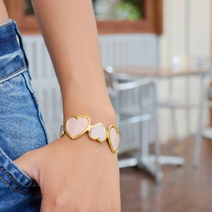 18K gold stainless steel heart cuff bracelet with pink enamel inlay on female wrist