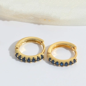 Detail of gold-plated hoop earrings featuring micro-set dark blue zircon gemstones