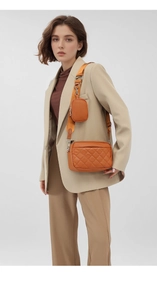 Detail of orange quilted leather crossbody bag with wide strap and detachable coin purse