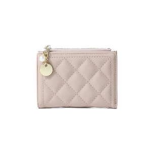 Detail of pink quilted wallet featuring a gold zipper and a pearl charm pendant