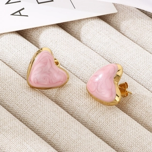 Detailed close-up of pink marble enamel heart earrings with gold trim and stud backing