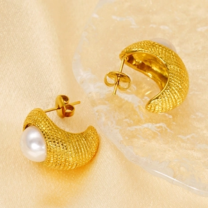 Boucles d'oreilles demi-cercles dorées texturées avec perles sur fond soie