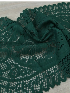 Close-up of deep green lace table runner with intricate crochet patterns on wood