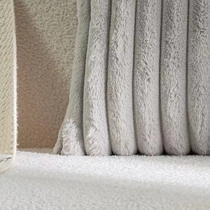 Detailed close-up of light gray faux rabbit fur pillow with vertical striped texture