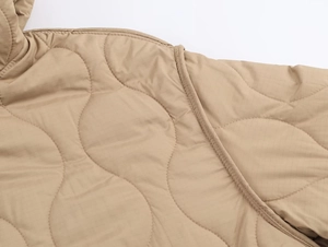 Close-up of khaki quilted jacket showing ripstop fabric texture and stitching detail