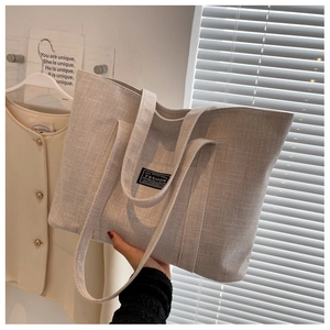 Detailed macro view of beige linen tote bag fabric with fashion logo and black label