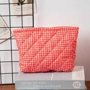 Detail of red and white gingham quilted cotton makeup bag showing soft diamond texture