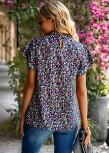 Detail view of the floral blue top back with hollow-out button and ruffled sleeves