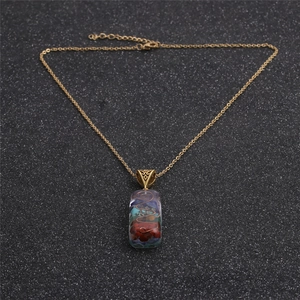 Gold chain necklace with a rectangular resin pendant featuring colorful crushed stones