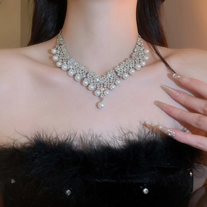 Gros plan d'un collier en argent avec perles et diamants sur un mannequin femme