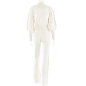 Detail of cream knit set featuring shoulder buttons, high neck, and lantern sleeves