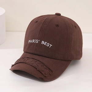 Detail of the white PARIS' BEST embroidery and distressed texture on a brown cotton cap