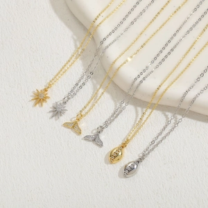 Collection of fishtail and star sun pendants in 14K gold and silver with zircon accents