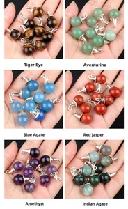Macro shot showing diverse natural gemstone wizard hat pendants held in hand