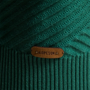 Close-up of dark green herringbone knit sweater featuring a brown leather brand patch