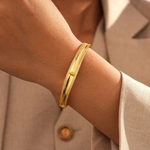 Close-up of 18k gold plated bangle featuring micro-pave zircons and a 3D heart charm