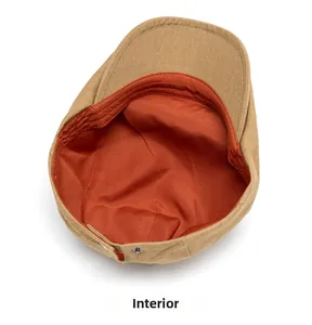 Detail of khaki newsboy cap interior featuring orange lining and silver snap button