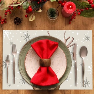 Christmas table mat with grey reindeer antlers and snowflakes on beige wood surface