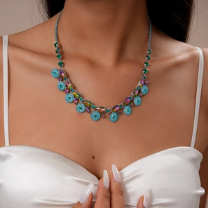 Detail shot of vintage crystal necklace with blue rhinestones and emerald-toned gems