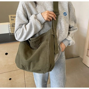 Detail view of large army green canvas tote with adjustable strap and front pocket