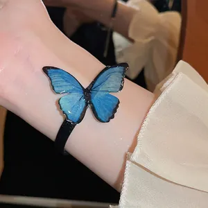 Blue butterfly jewelry set with gradient wings shown as a bracelet on woman's wrist