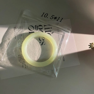 Close-up of a translucent yellow jade bracelet in a clear anti-oxidation storage bag