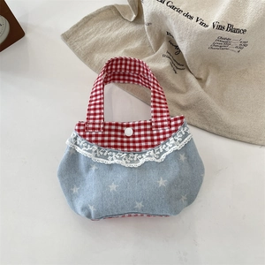 Dettaglio della mini borsa in denim blu con stelle bianche e bordo in pizzo vichy rosso