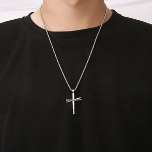 Collier pour homme en acier titane argenté avec pendentif croix porté par un mannequin
