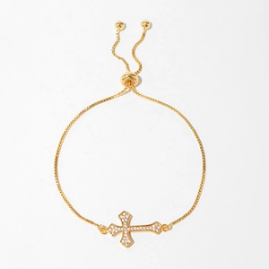 Adjustable gold butterfly and cross bracelet with white zircon accents on white background