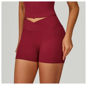 Detail of high waisted V-shaped cross waistband and side pockets on burgundy yoga shorts