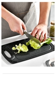 Close-up of black marble textured non-slip plastic cutting board with lettuce
