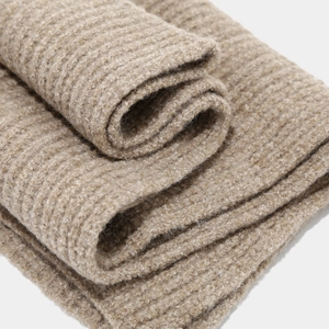 Macro shot of thick beige rib-knit scarf fabric texture with soft wool-like fuzzy fibers