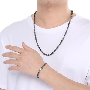 Minimalist dark grey stainless steel chain necklace and bracelet set on white t-shirt