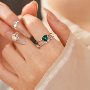 Gros plan d'une bague en argent sertie d'un zircon vert et de pierres blanches