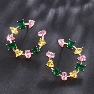 Detail of gold earrings featuring colorful heart and pear shaped zircon stones
